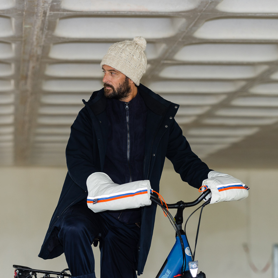Utilisateur à vélo portant les manchons recyclés, protection mains contre le froid et la pluie pendant le trajet.
