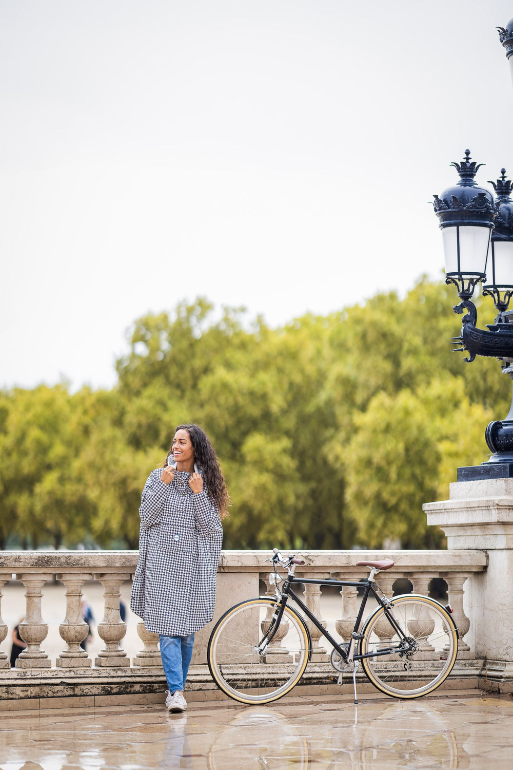 Utilisateur à vélo portant le poncho Paris recyclable, coupe imperméable.
