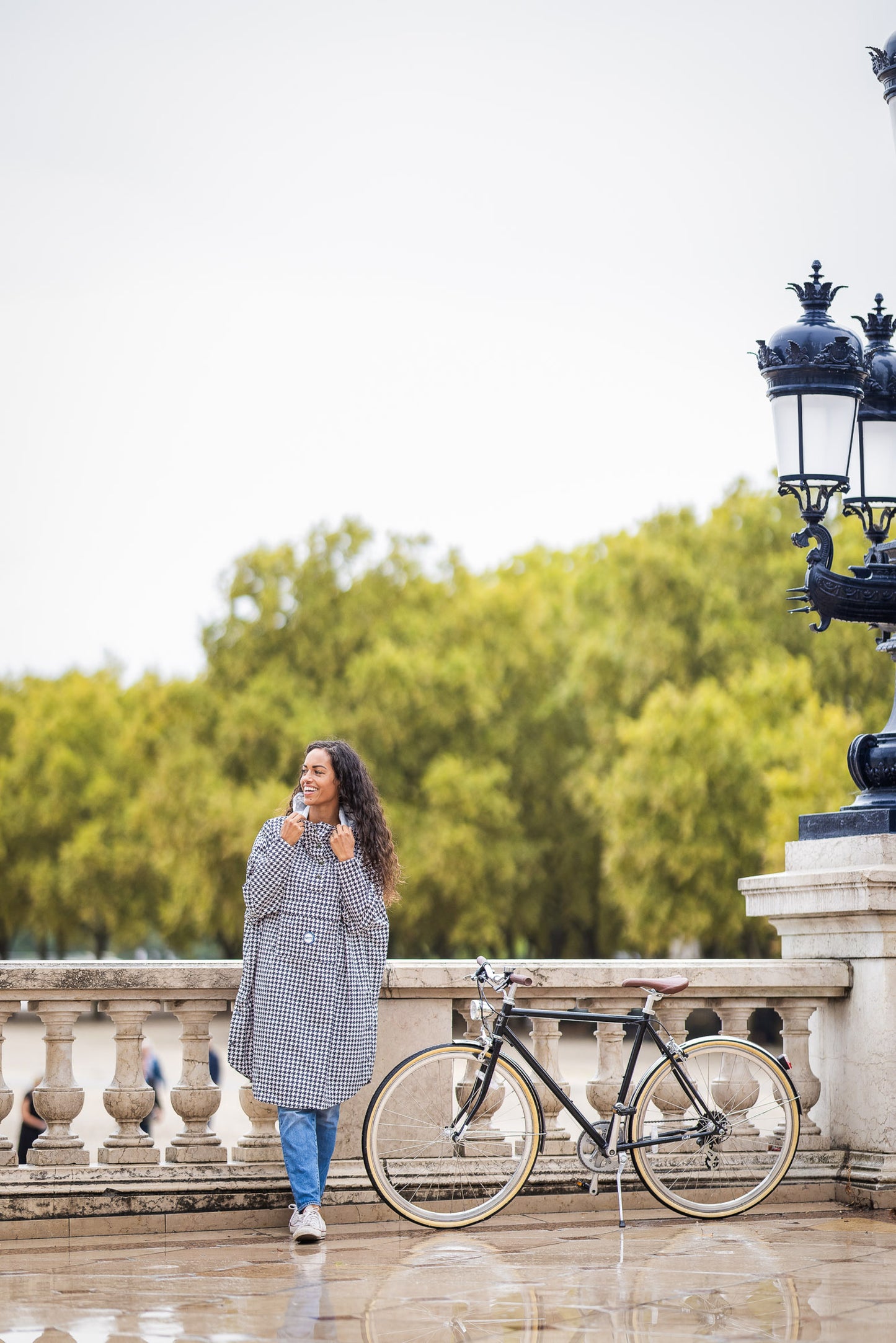 Utilisateur à vélo portant le poncho Paris recyclable, coupe imperméable.