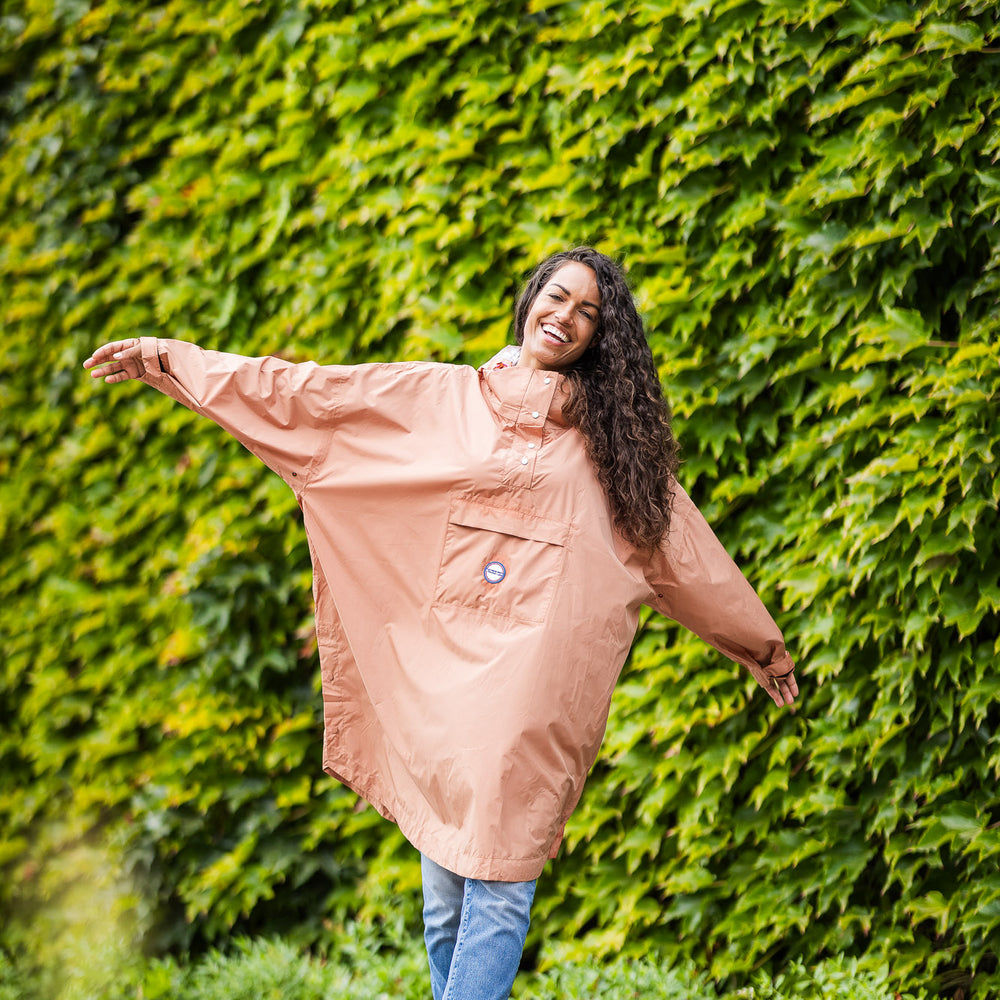 
                      
                        Utilisateur heureux portant le poncho Dublin couleur moka, coupe ample et protection imperméable contre la pluie.
                      
                    