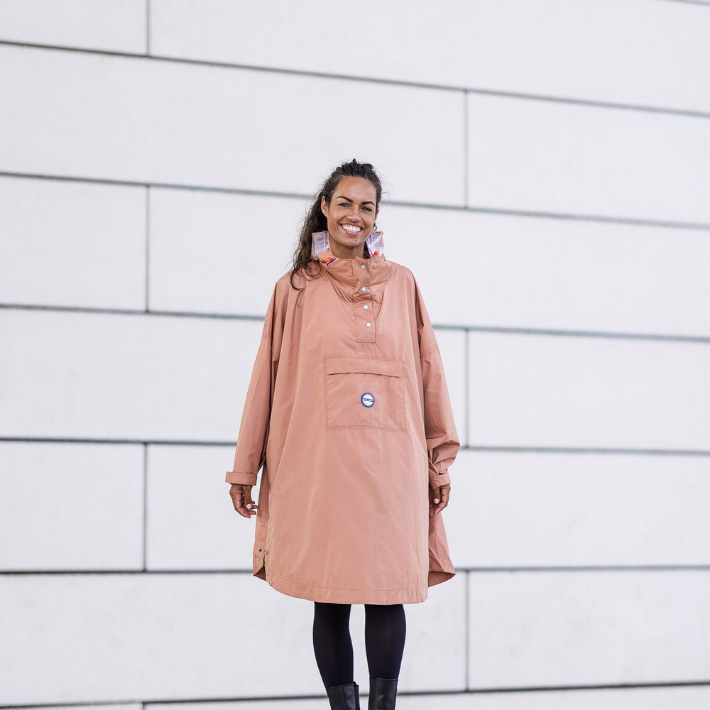 
                      
                        Poncho Dublin  de face avec boutons bleus et pochette de rangement intégrée, coupe ample et imperméable
                      
                    