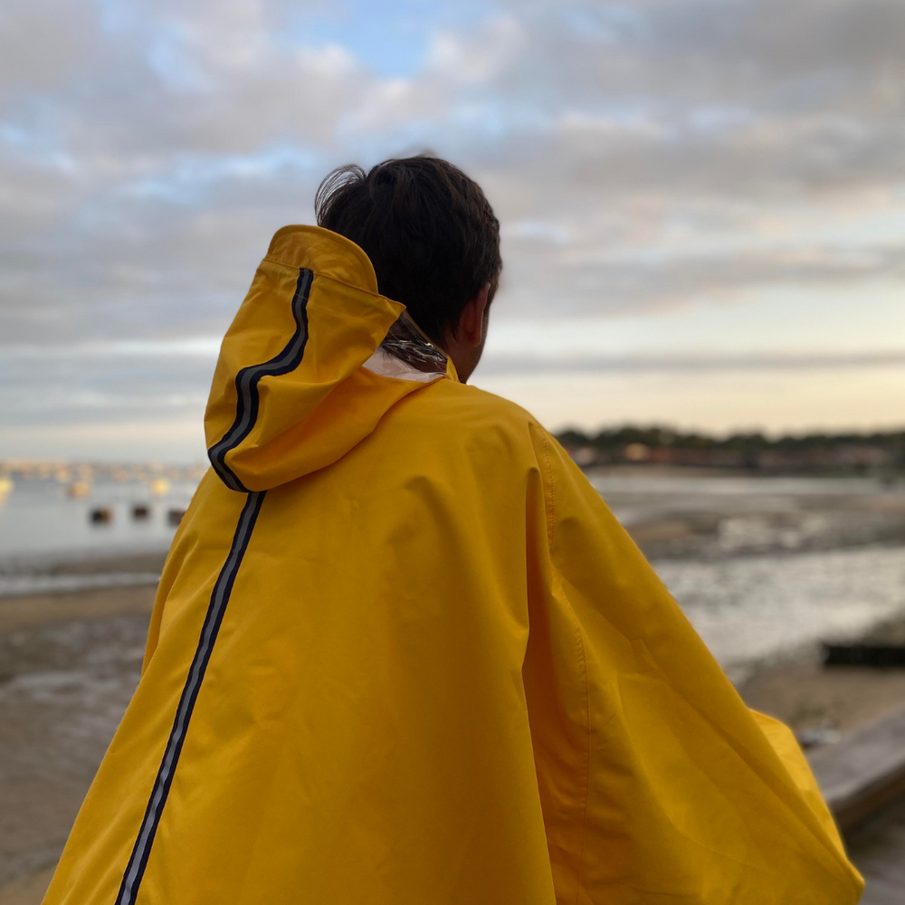 Vue de dos de la cape Cap Breton recyclée, montrant la coupe ample et les bandes réfléchissantes pour visibilité et sécurité.