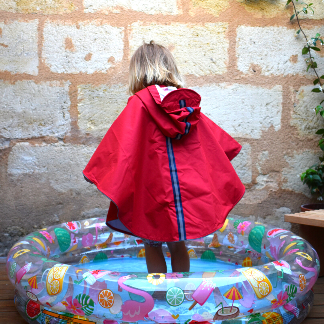 Détail de la bande réfléchissante de la cape de pluie enfant 5-7 ans pour une meilleure visibilité.