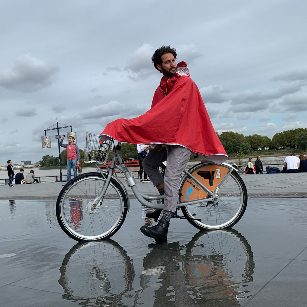 
                      
                        Cycliste portant la cape Cap Horn sous la pluie, protection imperméable et visibilité.
                      
                    